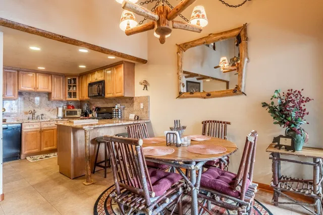 a kitchen with a dining table chairs and stove
