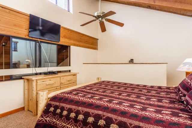 a bedroom with a bed and a flat tv screen on the dresser