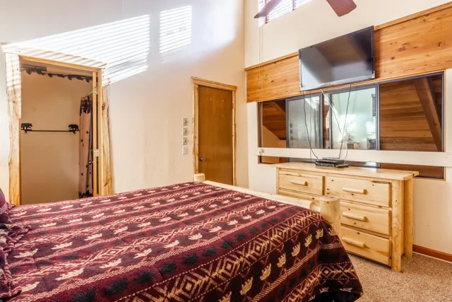 a bedroom with a bed and a large mirror on the dresser