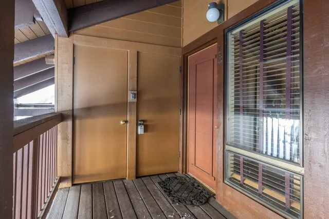 a view of a porch with wooden floor and a gate