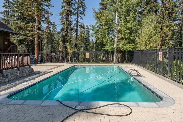 a view of a swimming pool with a patio and a yard