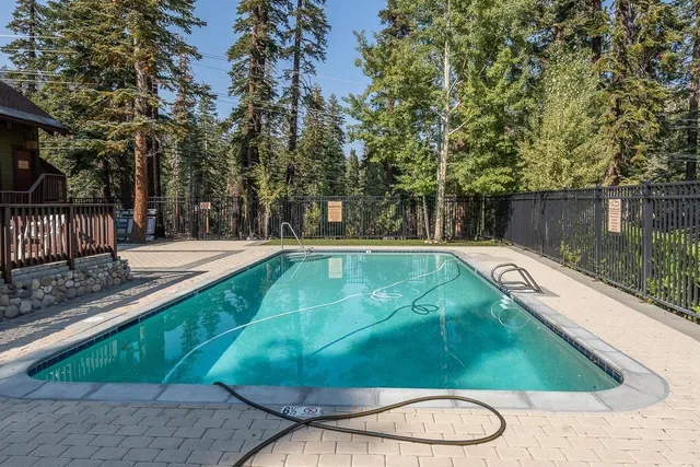 a view of a swimming pool with a patio and a yard