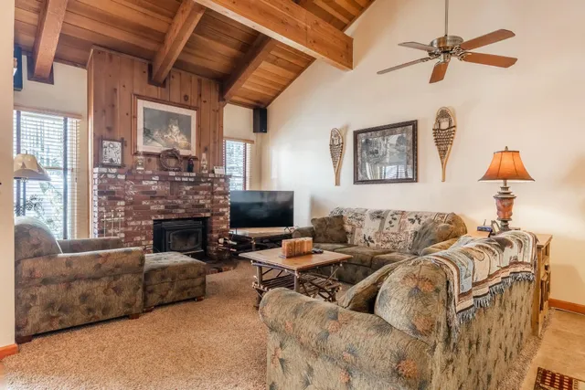 a living room with furniture a fireplace and a chandelier