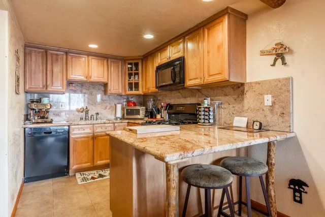 a kitchen with granite countertop a sink stove and refrigerator