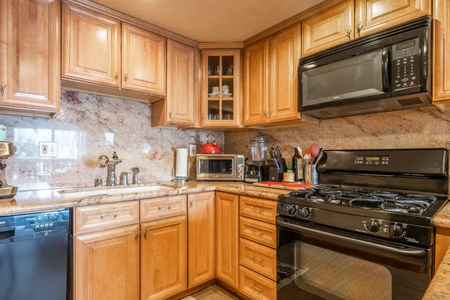 a kitchen with stainless steel appliances a stove a sink and a microwave