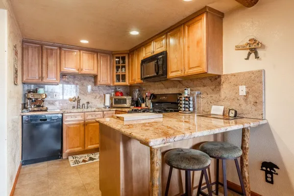 a kitchen with granite countertop a sink stove and refrigerator