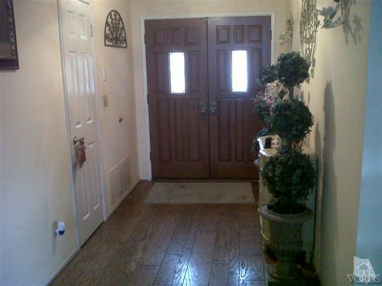 596 Fresh Meadows Road Simi Valley, CA 93065 - Photo 2 of 16 a view of a hallway with wooden floor and a potted plant