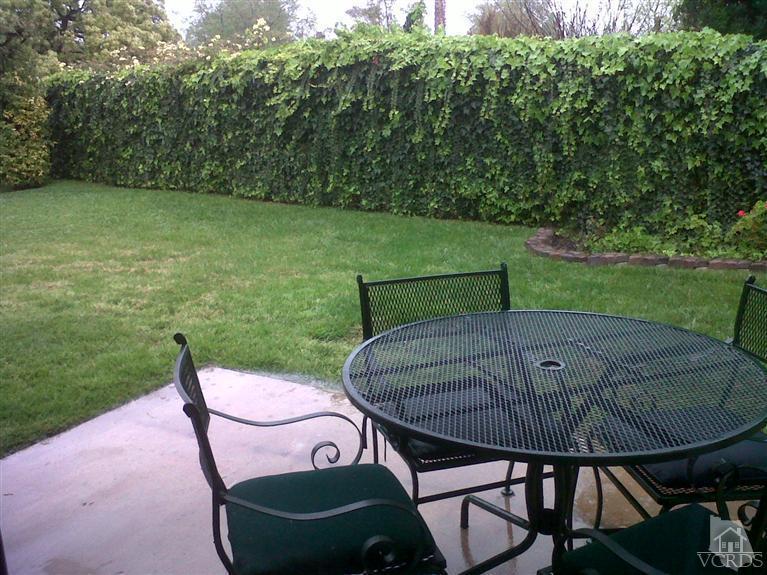 596 Fresh Meadows Road Simi Valley, CA 93065 - Photo 14 of 16 a view of a chairs and table in patio next to a yard
