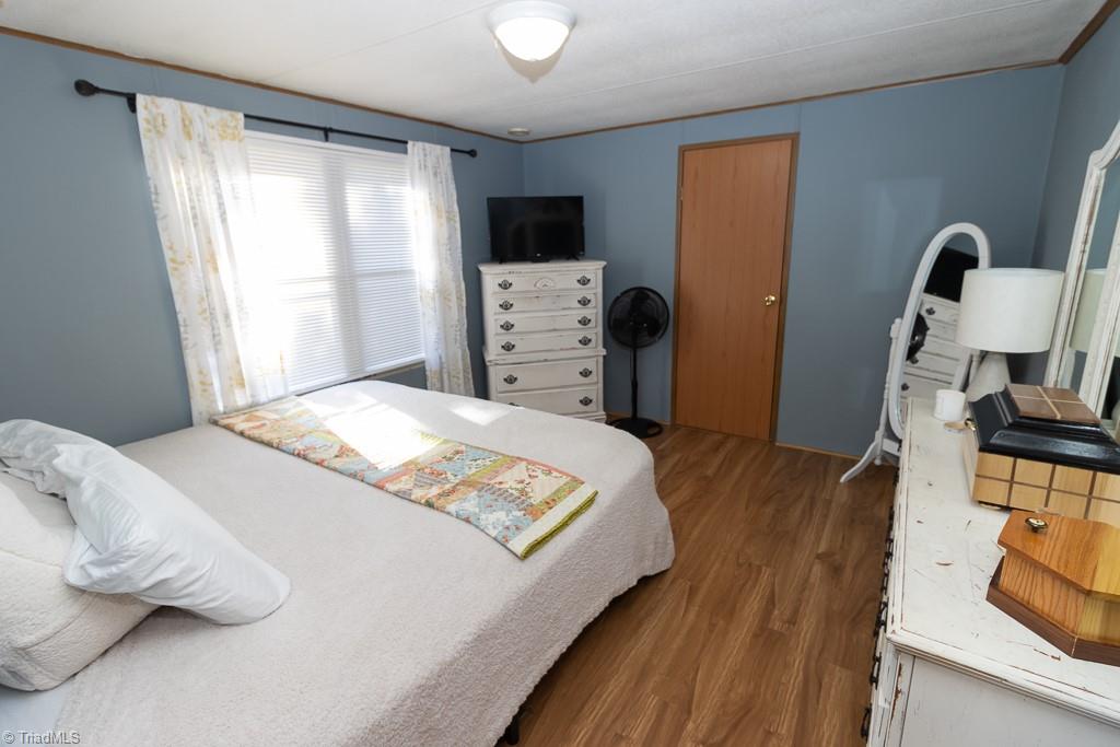 8280 Stafford Mill Road Oak Ridge, NC 27310 - Photo 20 of 40 PRIMARY BEDROOM WITH VINYL PLANK WOOD LOOK FLOORS. BATHROOM IS ATTACHED .