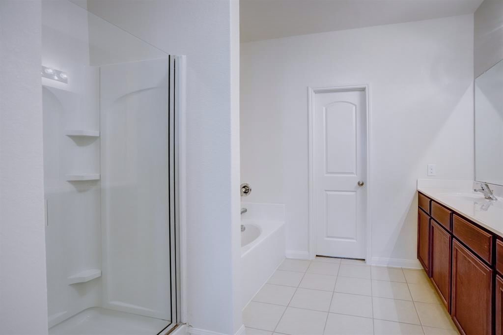 1303 Emerald Stone Drive Rosharon, TX 77583 - Photo 13 of 25 Beautifully appointed primary bath offering dual sinks, a separate shower, and a tranquil soaking bathtub.