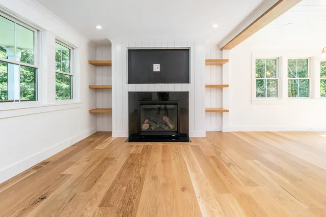 a view of empty room with a fireplace and windows