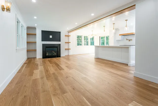a view of empty room with wooden floor and windows