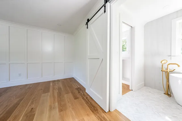 a view of a room with wooden floor and white walls