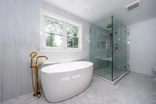 a white bath tub sitting next to a shower