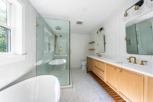 a spacious bathroom with a granite countertop tub sink and mirror