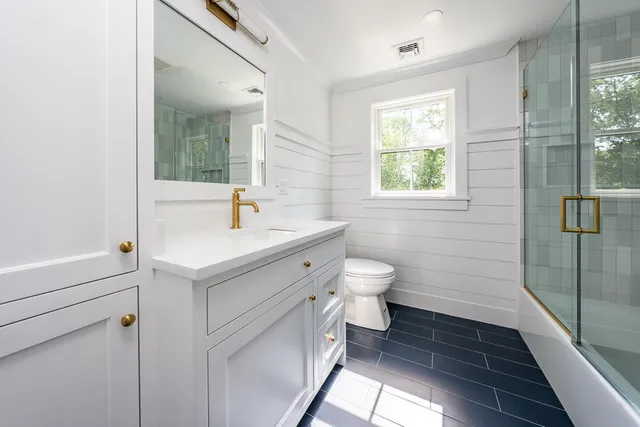 a bathroom with a sink toilet a mirror and shower
