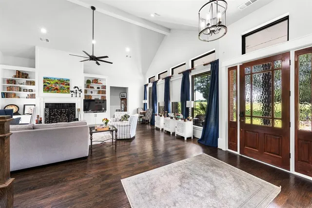 a living room with furniture a flat screen tv and a floor to ceiling window