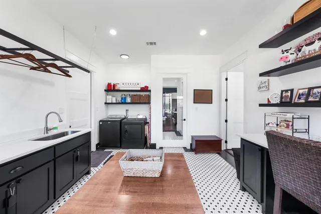 a living room with stainless steel appliances furniture a rug and a kitchen view