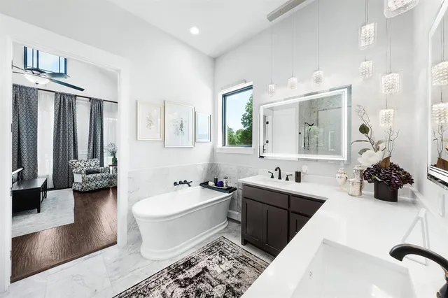 a spacious bathroom with a double vanity sink a mirror a bathtub and a shower