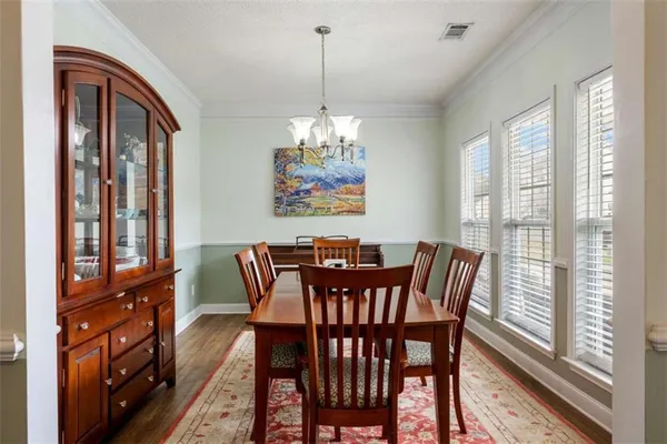 a view of a dining room with furniture wooden floor and a chandelier