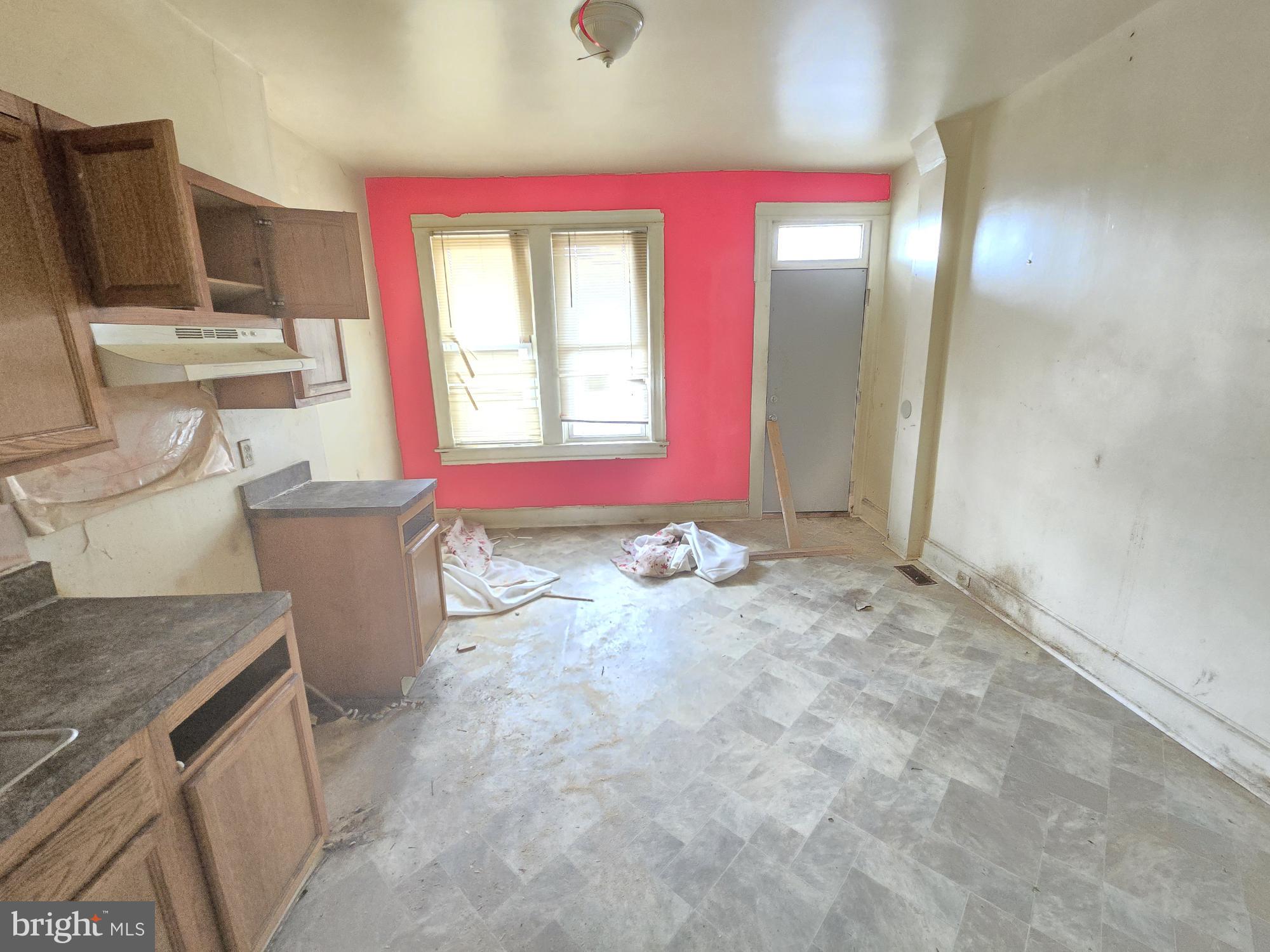 653 Bartlett Avenue Baltimore, MD 21218 - Photo 7 of 14 a view of a kitchen with a sink wooden cabinets and chair