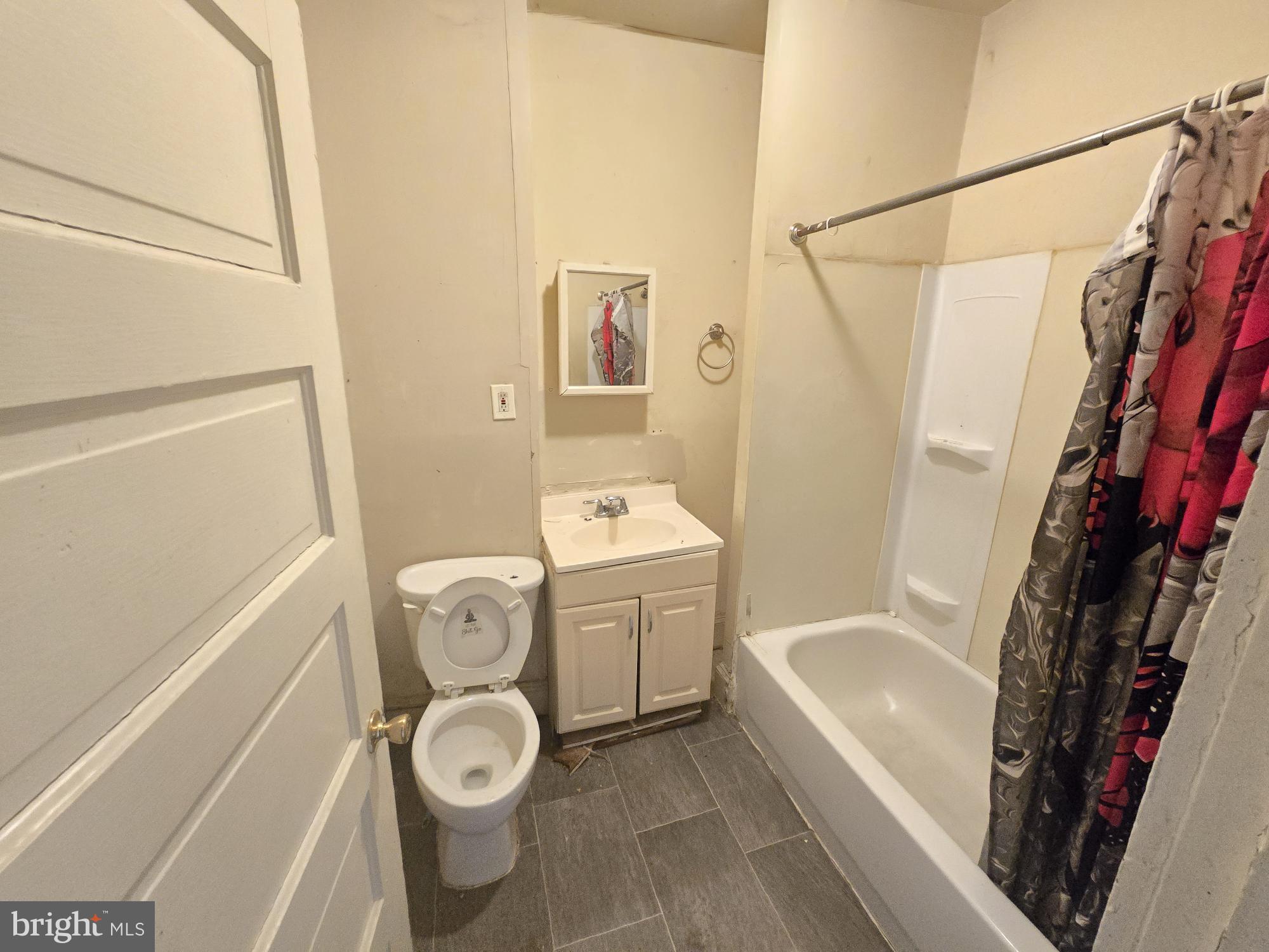 653 Bartlett Avenue Baltimore, MD 21218 - Photo 10 of 14 a bathroom with a toilet sink and mirror