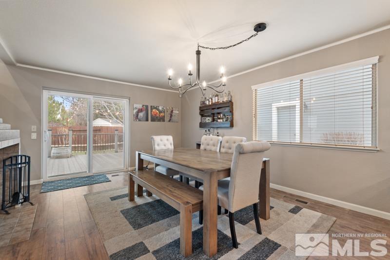 7595 Whimbleton Way Reno, NV 89511 - Photo 7 of 36 a dining room with furniture a chandelier and wooden floor