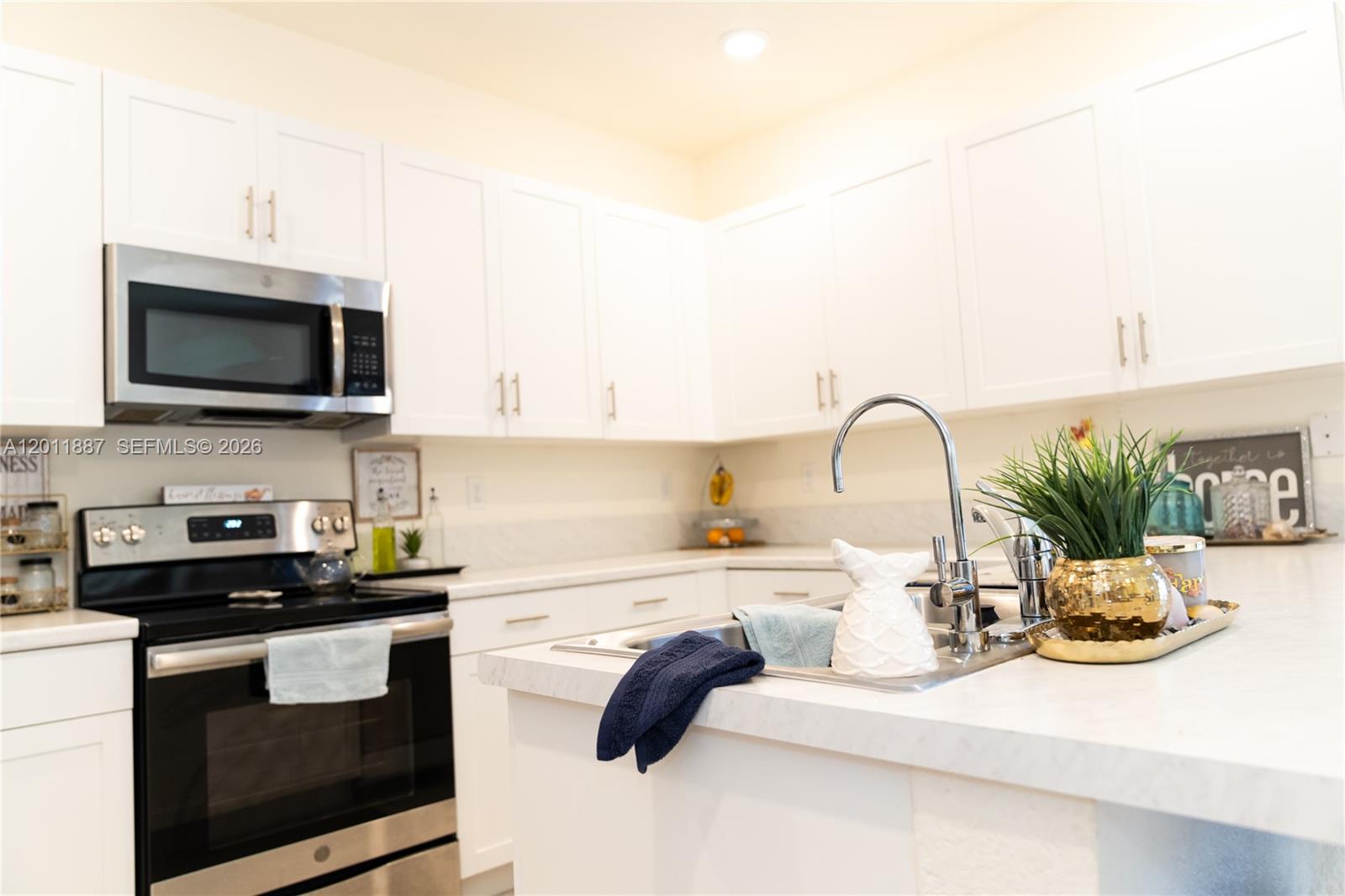 10599 West 33rd Court Hialeah, FL 33018 - Photo 11 of 39 a kitchen with a sink and a stove top oven with wooden floor