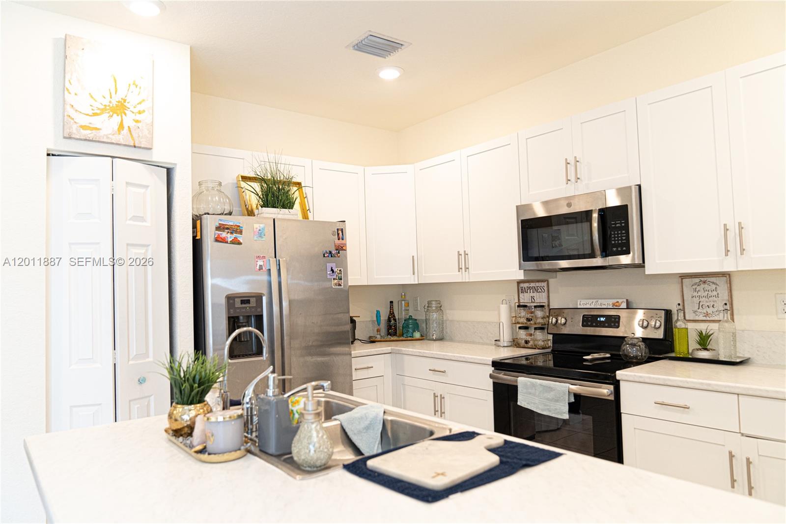 10599 West 33rd Court Hialeah, FL 33018 - Photo 10 of 39 a kitchen with stainless steel appliances kitchen island granite countertop a refrigerator and a stove top oven