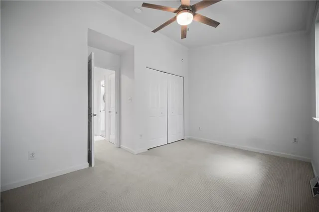 an empty room with a ceiling fan and a fan