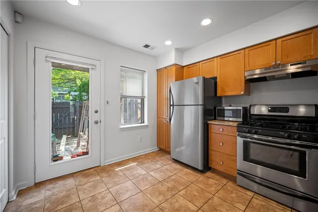 a kitchen with a refrigerator a stove and cabinets