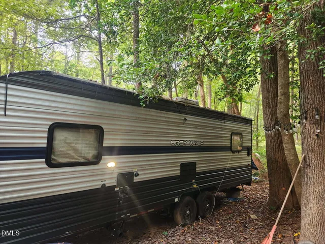 a view of a house with a yard and large tree