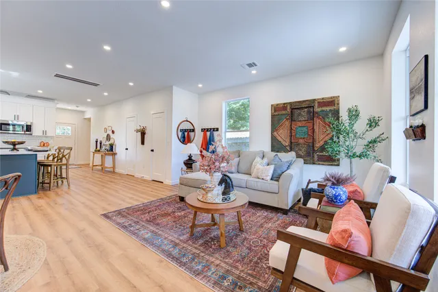 a living room with furniture and a dining table with kitchen view