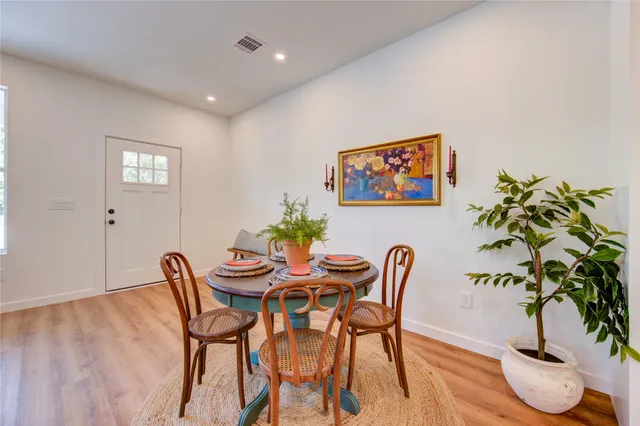 an open kitchen with wooden floor and stainless steel appliances
