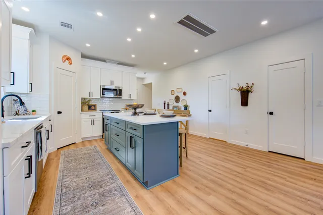 a kitchen with stainless steel appliances kitchen island granite countertop a sink and a stove