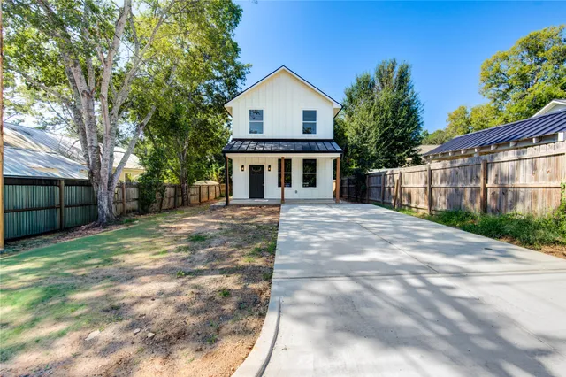 a front view of a house with a yard and potted plants