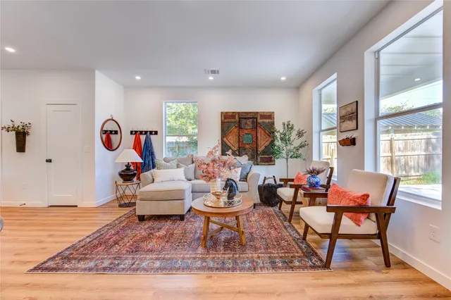 a living room with furniture a window and a wooden floor