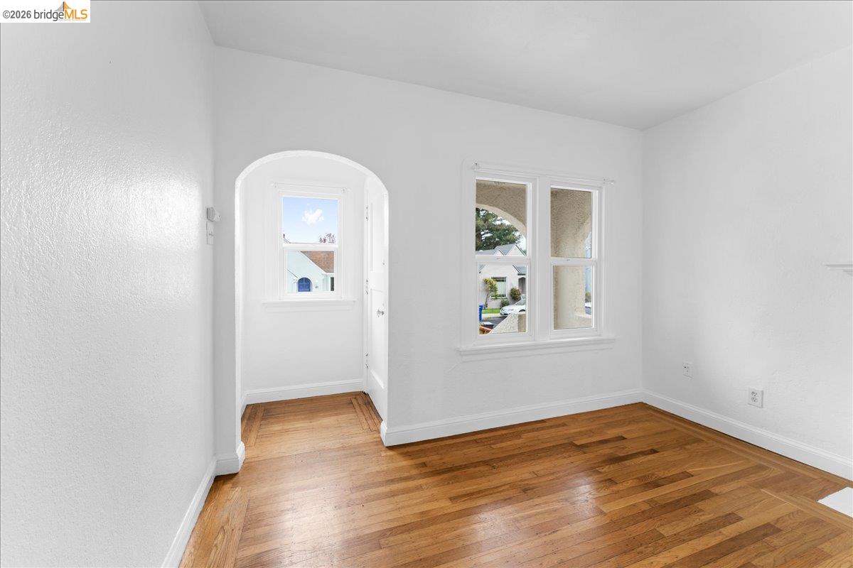 1127 Key Rte Boulevard Albany, CA 94706 - Photo 27 of 36 Empty room featuring light wood-type flooring and arched walkways