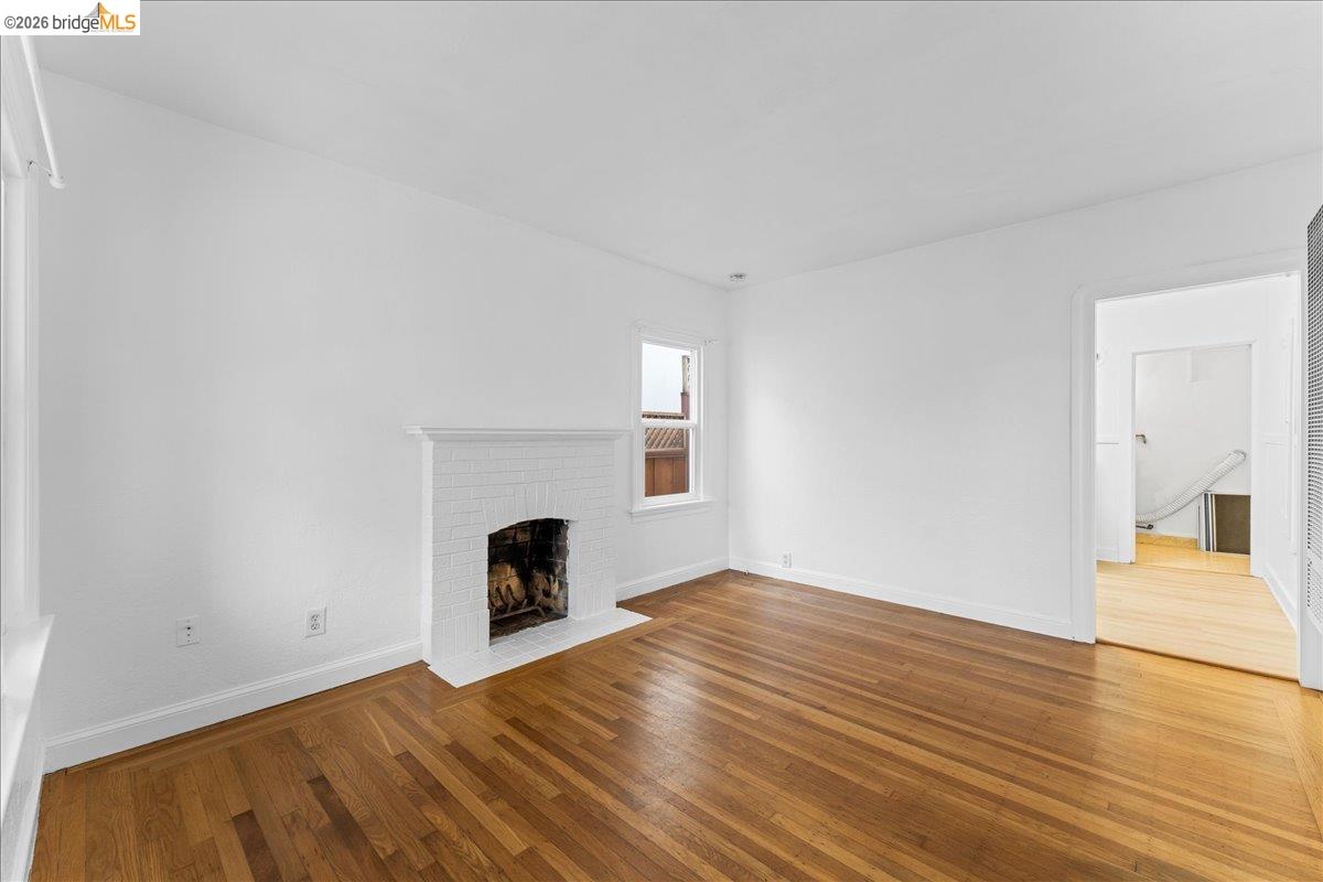 1127 Key Rte Boulevard Albany, CA 94706 - Photo 28 of 36 a view of empty room with wooden floor and fireplace