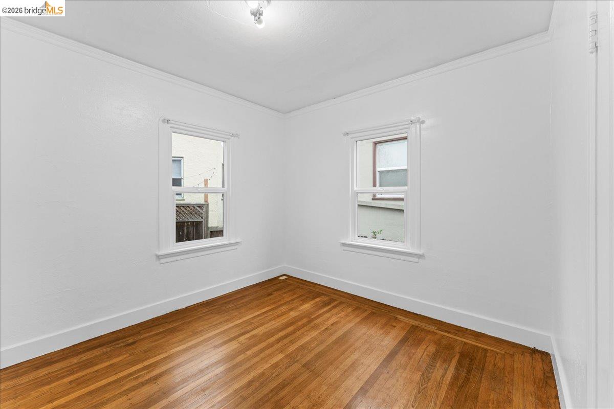 1127 Key Rte Boulevard Albany, CA 94706 - Photo 7 of 36 Unfurnished room featuring hardwood / wood-style floors, crown molding, and healthy amount of natural light