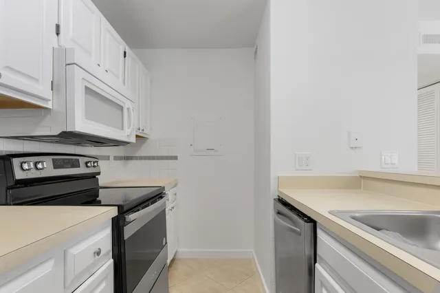 a view of a kitchen with white cabinets and a stainless steel appliances
