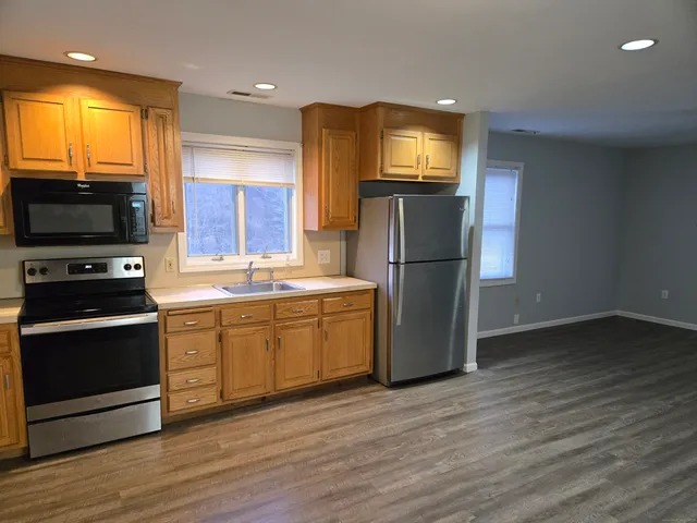 a kitchen with a refrigerator and a stove top oven