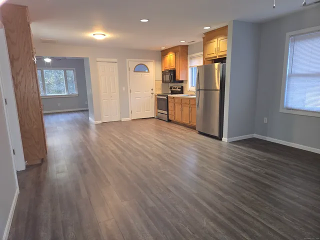 a view of kitchen view wooden floors appliances and cabinets