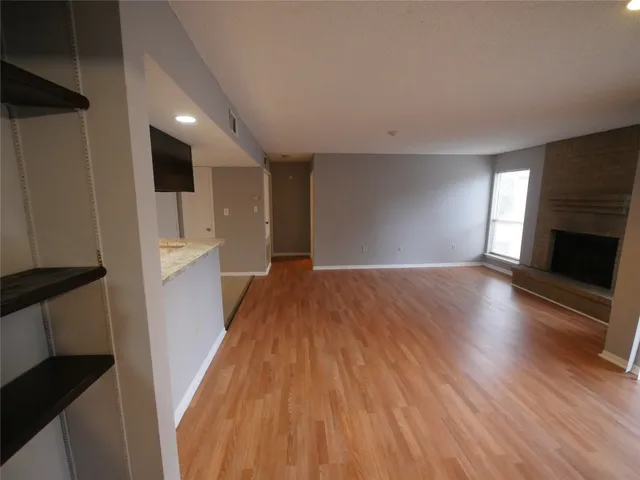a view of a hallway with wooden floor and a fireplace