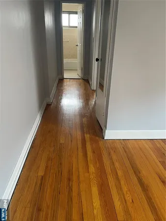 a view of a hallway with wooden floor