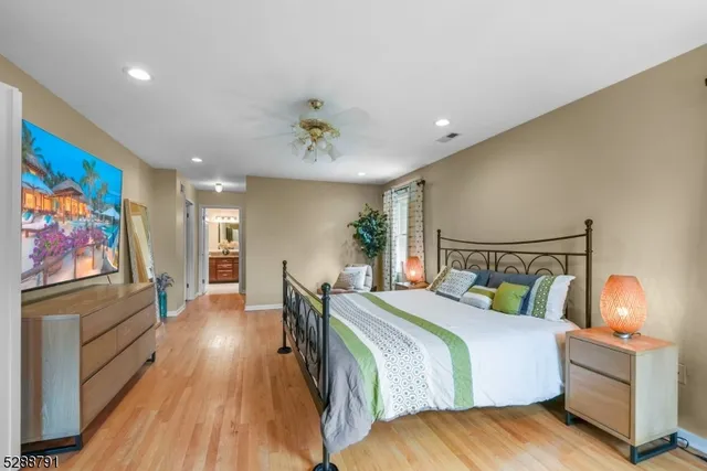a bedroom with bed and wooden floor