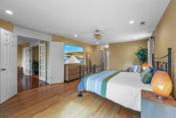 a spacious bedroom with a bed and wooden floor