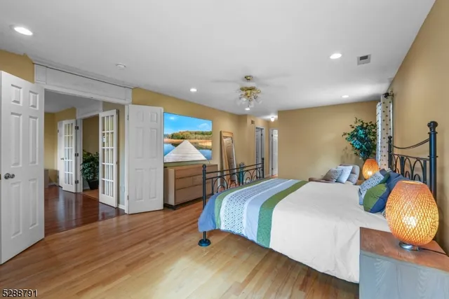 a spacious bedroom with a bed and wooden floor