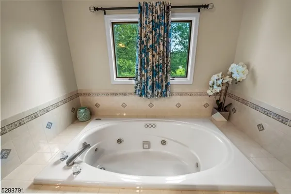 a bedroom with a large bed a chandelier and windows