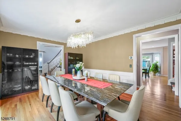 a dining room with furniture a chandelier and wooden floor
